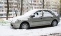 Renault Dacia Logan parked in winter near the house.