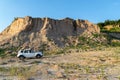 Renault Duster against the background of a high cliff of an old quarry