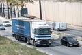 Renault Magnum truck loading a blue container trailer along Barcelona's Ronda Litoral