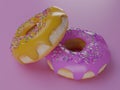 Render of two donuts lying on top of each other on a pink background