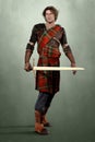 Handsome man in Highland warrior costume holding a sword