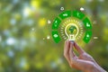 Renewable Energy. Hand holding light bulb and have green world map with icons energy sources for renewable, sustainable Royalty Free Stock Photo