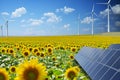 Renewable energy resources in natural environment with sunflower field, photovoltaic panels and windmills