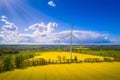 Renewable energy, wind energy with windmills. Wind turbines farm generating electricity on rapeseed fields - aerial view Royalty Free Stock Photo