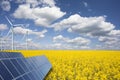 Renewable or green energy concept with wind turbines solar panels and yellow raps field on blue sky with clouds Royalty Free Stock Photo