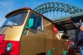 A rennovated classic van is used as a portable canteen serving pizza at Gateshead, Newcastle with Tyne Bridge in the background