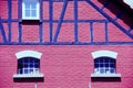 Old manicured barn with red wall and blue truss