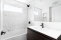 A bathroom with a wood cabinet and marble tile shower. Royalty Free Stock Photo