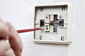 Renovated old light switch close-up, unscrewed bolt with screwdriver. Royalty Free Stock Photo