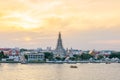 Renovated Wat Arun The Temple of Dawn with boats moving over Chaophraya river in the evening in Bangkok, Thailand