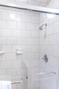 Renovated white subway tile bathroom shower with glass door Royalty Free Stock Photo