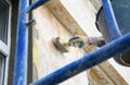 Renovating external house facade wall. A man is applying the primer coat with a brush before rendering and plastering the house Royalty Free Stock Photo