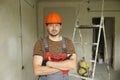 Renovation apartment. Portrait of young confident male foreman constructor repairman in safety hard hat and overalls