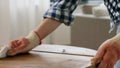 woman degreasing old table surface with solvent