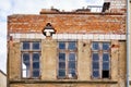 Renovation of the facade of an old house with broken old wooden windows. New and old bricks Royalty Free Stock Photo