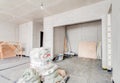 Renovation home. Building construction interior site with concrete walls, building materials and scaffolding in light Royalty Free Stock Photo