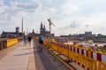 Renovation of old, historic Augustus Bridge on Elbe River. People walking on temporary side-walk bordered by yellow barrier Royalty Free Stock Photo