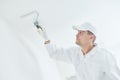 Painting. Painter with paint roller covering ceiling with white paint Royalty Free Stock Photo