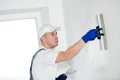 Refurbishment. Worker spackling a wall with putty