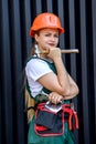 Renovation and remodelling concept. Woman in helmet and protective mask posing with hammer and spatula