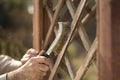 Renovation works in the garden. A man cleans the boards of the garden bench by a wire brush. Removing old paint. Royalty Free Stock Photo