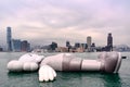 Art, Istallation, Floating Sculpture, Hong Kong. Gigantic dead grey mouse drifting on water at cloudy day, Hong Kong Island