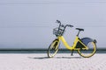 Rent a bike, a yellow bike stands against a gray wall