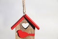 Rent concept. Wooden Christmas toy house with red roof and bird on white background. Christmas decoration concept. Small Royalty Free Stock Photo