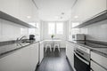 Rental apartment kitchen with gloss white cabinets, gray granite