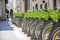 Rental bicycles with electric motors stand in row on street of Paris ready to ride everyone Royalty Free Stock Photo