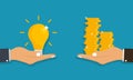 Hand holds light bulb with idea and giving receiving golden coins from other hand. Concept for business idea sell Royalty Free Stock Photo