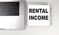 RENTAL INCOME text on notebook with laptop and pen