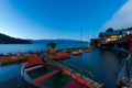 Rental row boats on pier at mountain lake Walchensee in Bavaria, Germany at dawn in early morning with boat house Royalty Free Stock Photo