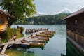 Rental row boats on pier at mountain lake Walchensee in Bavaria, Germany on sunny day with boat house Royalty Free Stock Photo