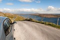 Rented car parked off road with epic view on a mountains. Sky road, near Clifden town, county Galway, Ireland. Warm sunny day with