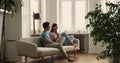 Renters couple talking seated on sofa in living room