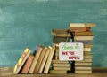 Reopening bookshops after the corona lockdown, stack of books and open sign,symbolic Royalty Free Stock Photo
