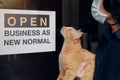 Reopening for business adapt to new normal in the novel Coronavirus COVID-19 pandemic. A cat with their owner person wearing mask