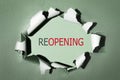 Reopening business, economy recovery after lockdown end concept. Word reopening on torn paper background