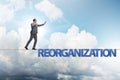 Reorganisation concept with businessman walking on tight rope Royalty Free Stock Photo