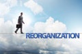 Reorganisation concept with businessman walking on tight rope Royalty Free Stock Photo