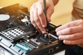 Repaiman with screwdriver fixing disassembled laptop parts. Technical support and fixing gadgets problems. Servicing Royalty Free Stock Photo