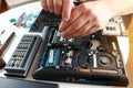 Repaiman with screwdriver fixing disassembled laptop parts. Technical support and fixing gadgets problems. Servicing Royalty Free Stock Photo