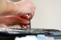 Repaiman with screwdriver fixing disassembled laptop parts. Technical support and fixing gadgets problems. Servicing Royalty Free Stock Photo