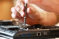 Repaiman with screwdriver fixing disassembled laptop parts. Technical support and fixing gadgets problems. Servicing Royalty Free Stock Photo