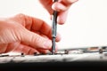 Repaiman with screwdriver fixing disassembled laptop parts. Technical support and fixing gadgets problems. Servicing Royalty Free Stock Photo