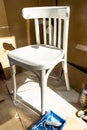 Repainting an old chair. Old white wooden chair, paint and brush.