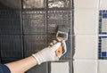 Repainting old dated kitchen ceramic tile back wall with modern gray chalk paint indoors at home. Royalty Free Stock Photo