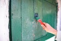 Repainting Wooden Old Door. Worker hand with brush painting wooden door