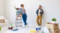 Repair in apartment. Happy family mother, father and child daughter  paints wall Royalty Free Stock Photo